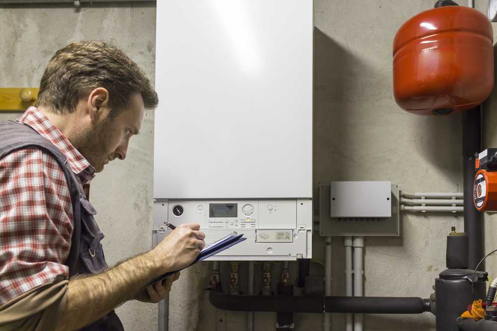 Plombier effectuant un entretien sur un chauffage à condensation